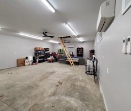 Custom garage lighting and climate control installation. Features energy-efficient LED strip fixtures for complete, shadow-free coverage, dual ceiling fan installations, and dedicated wiring for a wall-mounted ductless mini-split AC system.