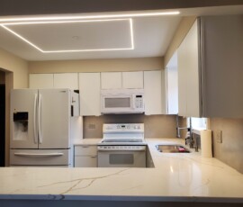 Contemporary kitchen lighting layout featuring flush ceiling perimeter LED tracks and clean under-cabinet task lighting.