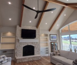 Custom living room illumination highlighting stone masonry features and architectural shelving displays.