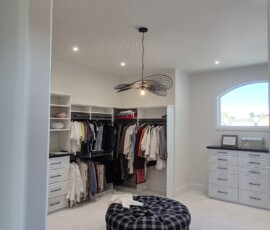 Premium closet lighting design. Features strategic placement of flush recessed LED downlights to eliminate shadows across custom cabinetry, paired with a central artistic accent pendant light fixture.